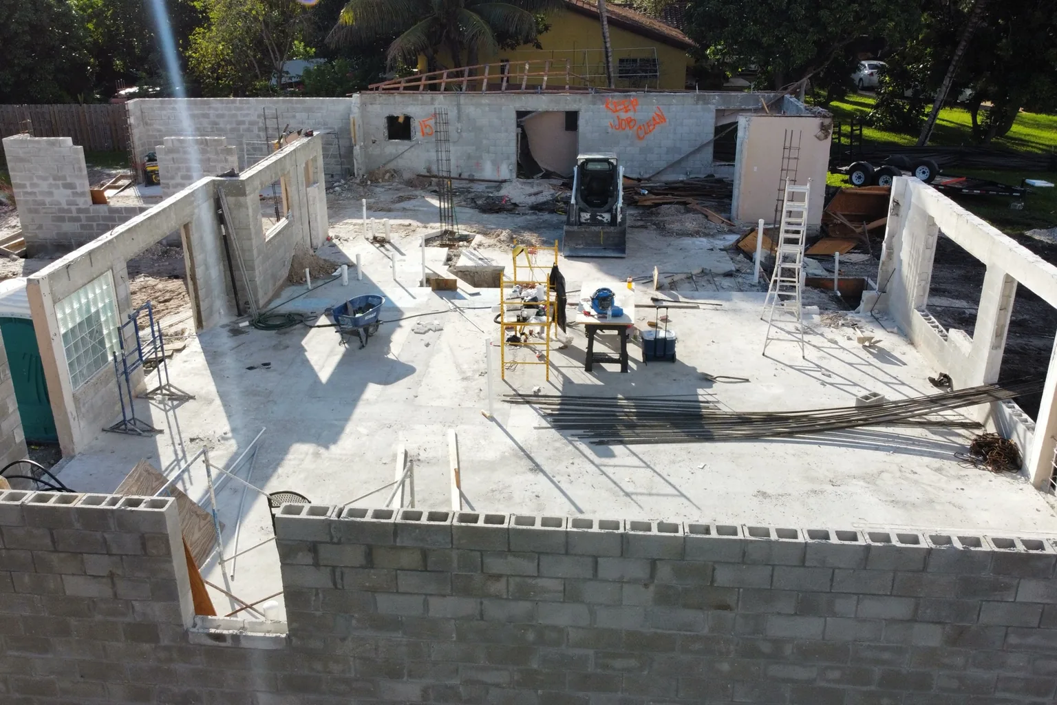 Aerial view of block walls up to tie-beam height with rebar standing in filled cells