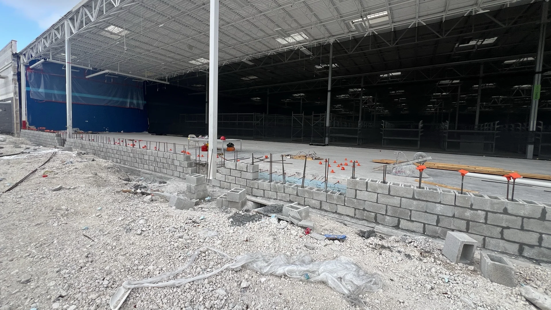 CMU walls laid inside a steel-frame commercial building, vertical reinforcing standing in the cells