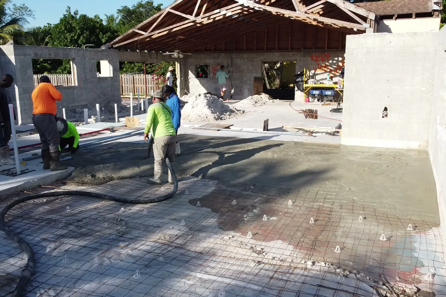 Concrete pumped over reinforcing mesh on chairs inside block walls