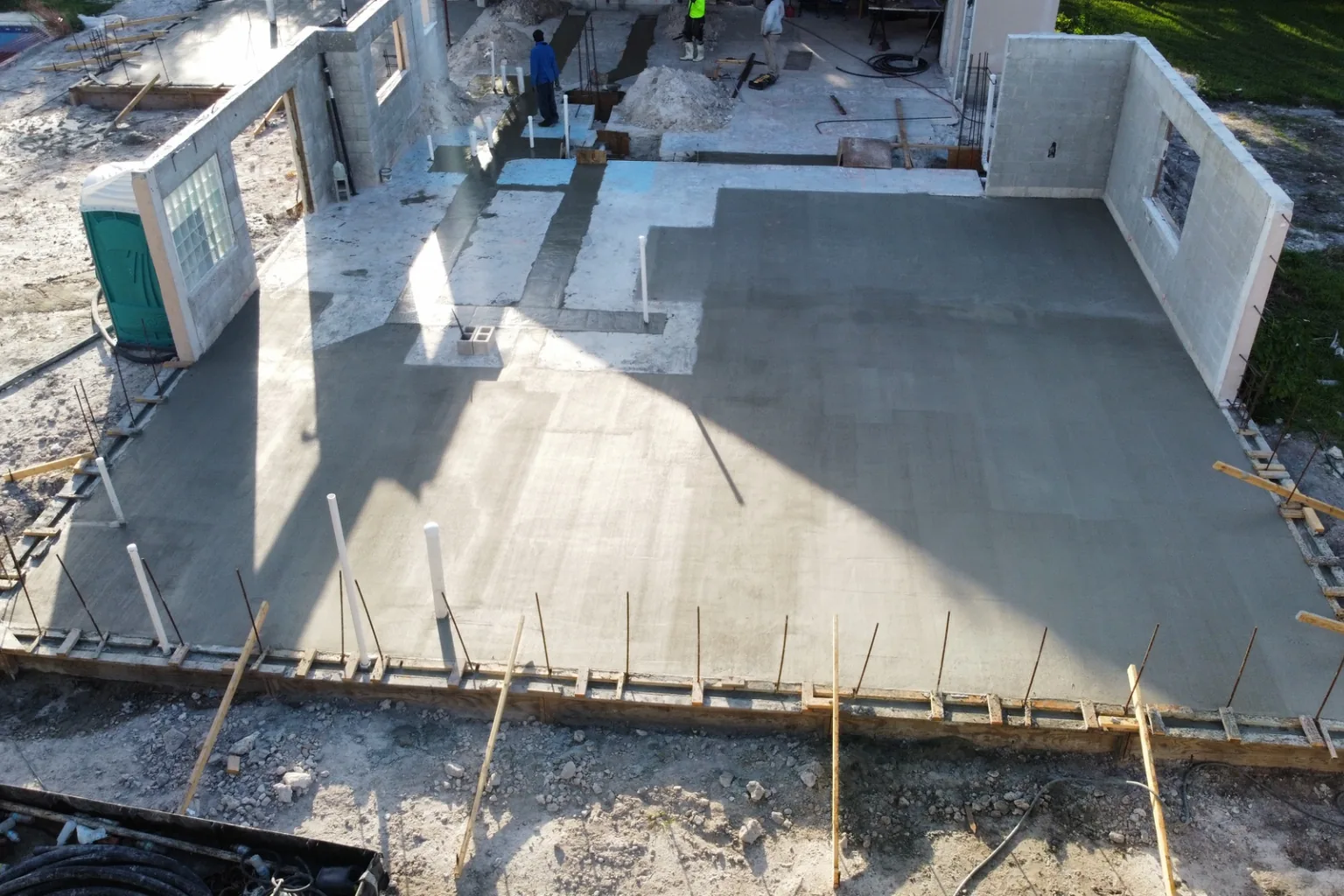 Freshly finished slab with forms still set and dowels standing